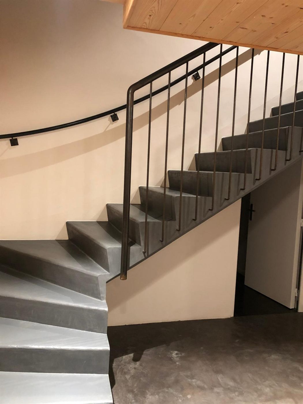 Escalier en béton ciré gris avec garde-corps métallique noir